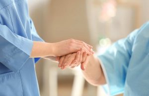 Doctor holding patients hand discussing end of life care